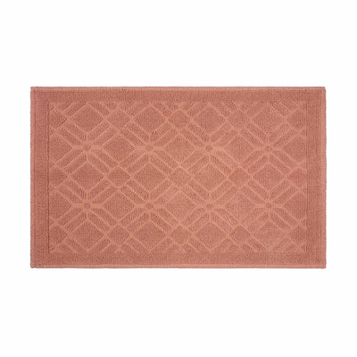 Rectangular bath rug in a soft coral color with a geometric pattern and a textured surface.