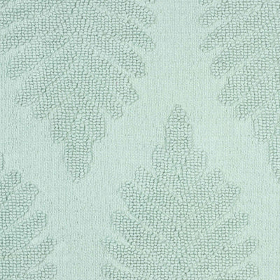 Light green bath rug featuring a textured fern ogee pattern.